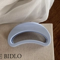 Detailed macro view of the light blue matte crescent moon hair claw clip on fabric - Light Blue Solid Hollow Crescent Claw
