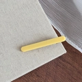 Gros plan détaillé d'une pince à cheveux jaune mat sur un fond en bois rustique naturel - Jaune Fromage Barrette Bec de Canard Droite