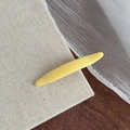 Gros plan sur la pince à cheveux jaune mat minimaliste sur fond rustique en lin et bois - Jaune Fromage Barrette Feuille de Saule