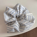 Détail d'un chouchou à rayures bleues et blanches avec étiquette tissée Made in Korea - Chouchou Frais Bleu - Rayé