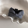 Vista detallada de una pinza para el pelo con lazo gris oscuro y textura de lino en plato - Gris Oscuro