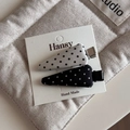 Detail of polka dot bow hair clips on display card with a soft quilted background - Black and White Pair - Triangle Duckbill Clip