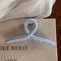Detail shot of light blue matte hair claw clip with golden metal spring on canvas - Light Blue Solid Hanger Style Claw