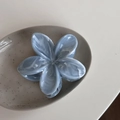 Dettaglio del fermaglio a fiore blu effetto marmo su un piatto in ceramica bianca - Marmo Fiore Blu