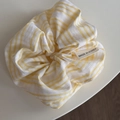 Dettaglio della fascia per capelli a quadretti gialli con etichetta di finitura tessile - Scrunchie Dolce - Righe Larghe