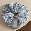 Gros plan sur un chouchou à carreaux bleus avec étiquette faite main sur tissu - Chouchou Frais Bleu - Plaid Moyen