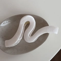 Macro detail of marble pattern hair claw on a ceramic tray with wave S-shape design - White Wave Marble