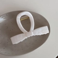 Macro shot of ink marble texture large acetate bow claw clip on ceramic dish - White Bowknot Marble