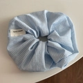 Détail macro du chouchou à carreaux bleu clair avec étiquette tissée fait main - Chouchou Frais Bleu - Plaid Fin