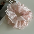 Gros plan sur un chouchou en dentelle rose avec texture crochet et perles dorées - Rose