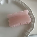 Detalle de una pinza para el cabello rosa ondulada con acabado perlado en un plato - Rosa Claro