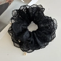 Détail d'un chouchou en dentelle noire avec pendentifs en perles dorées au style rétro - Noir