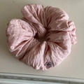 Detalle del coletero de tela rosa arrugada con un botón decorativo de lazo lila - Rosa