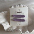 Dettaglio di due fermagli per capelli in resina viola su cartoncino bianco in una ciotola - Stile Ovale / Viola