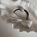 Dettaglio dell'elastico per capelli con fiocco strutturato panna e perla finta - Bianco Sporco Elastico Capelli