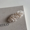 Détail montrant les couches de tulle plissé crème et la texture fine de la pince à cheveux - Pince Goutte Blanche