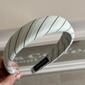 Detailed close-up of handmade mint green striped padded headband with textile logo - Fresh Striped Green Headband