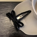 Detailed shot of large black satin ribbon hair clip on elegant white porcelain plate - Bow BB Clip / Black
