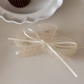 Detail of a large translucent beige bow hair claw clip with a delicate white silk ribbon - Beige
