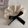 Detalle de coletero de encaje estilo francés con lazo de satén negro y textura floral - Encaje Crema - Lazo Negro