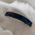 Macro-opname van een blauwe marmeren acetaat haarspeld met gouden Franse tekst - Blauw Paars Marmer