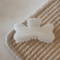 Close-up of translucent white hair claw clip with smooth texture on woven mat - White Glitter Jelly - Petal Knot