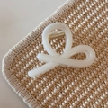 Close-up of a creamy white translucent hair claw clip with golden metal spring detail - White Glitter Jelly - Cross