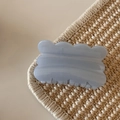 Macro shot of hazy blue wavy edge hair claw clip with pearlescent marble texture - Glitter Jelly Blue - Biscuit Shape