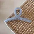 Vista dettagliata della molletta per capelli blu traslucida con una molla in metallo dorato - Blu Gelatina Glitter - Forma a Gruccia