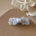 Vue détaillée d'une pince à cheveux en dentelle bleue avec perle en cœur sur une boîte - Nœud (Bleu)