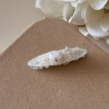 Détail d'une pince à cheveux en dentelle blanche avec perle cœur sur carte brune - Ovale (Beige)
