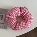Detail van rood-wit geruite stoffen scrunchie met zachte vulling en zijlabel - Rode Ruit
