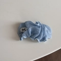 Détail du chouchou bleu clair avec un badge blanc orné d'un motif de nœud noir - Barrette BB en Gaze Plissée Bleue