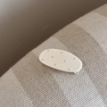 Gros plan sur une barrette ovale à pois bleu clair sur fond blanc avec clip argenté - Ovale (FJ892289) / Blanc