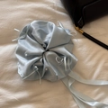 Dettaglio dell'elastico in raso celeste con perle e nastri su una base di tessuto bianco - Blu