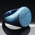 Macro detail of deep blue brushed stainless steel Viking compass ring with runes - Blue