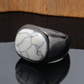 Macro shot of chunky black polished metal ring with natural white turquoise stone inlay - Black Color White Turquoise