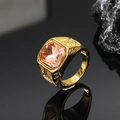 Macro shot of gold square peach gemstone ring with textured band on black mirror - Gold Champagne Gem