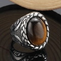 Makroaufnahme eines Vintage-Titanstahlrings mit Tigerauge-Stein und Flechtstruktur - US 7 / Stahl Tigerauge