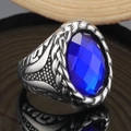Makroaufnahme eines Vintage Herrenrings mit blauem Edelstein und geflochtener Silbertextur - US 7 / Stahlfarben Blauer Edelstein