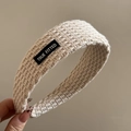 Close-up of beige knitted headband featuring a black TRUE FITTED patch and textured wool - Letter Patch Knitted Headband - Beige