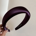 Detailed close-up of dark purple padded satin headband with a Hand Made label - Deep purple