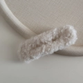 Close-up of soft plush texture on cream white hair clip with faux fur material - White