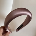 Detailed macro view of the handmade label on a thick pink satin padded headband - Champagne