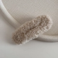 Detail showing plush lamb wool texture on oatmeal-colored hair clip for women - Creamy White