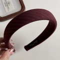 Gros plan détaillé du serre-tête rayé rouge bordeaux foncé avec texture douce et étiquette - Serre-tête Rembourré en Tissu à Rayures / Rouge