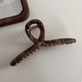 Detail shot of the large red and green tartan hair claw clip with its gold metal spring - Hanger