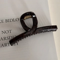 Detail view of a glossy leopard print hair claw clip with a twist design and gold spring - Shimmer Brown Leopard Cross Bar