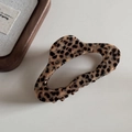 Vista dettagliata della molletta per capelli in acetato leopardato su sfondo minimalista - Stile Nuvola