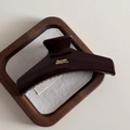 Macro view of chocolate brown hair claw clip with golden text and glossy finish - Chocolate-Hanger Style